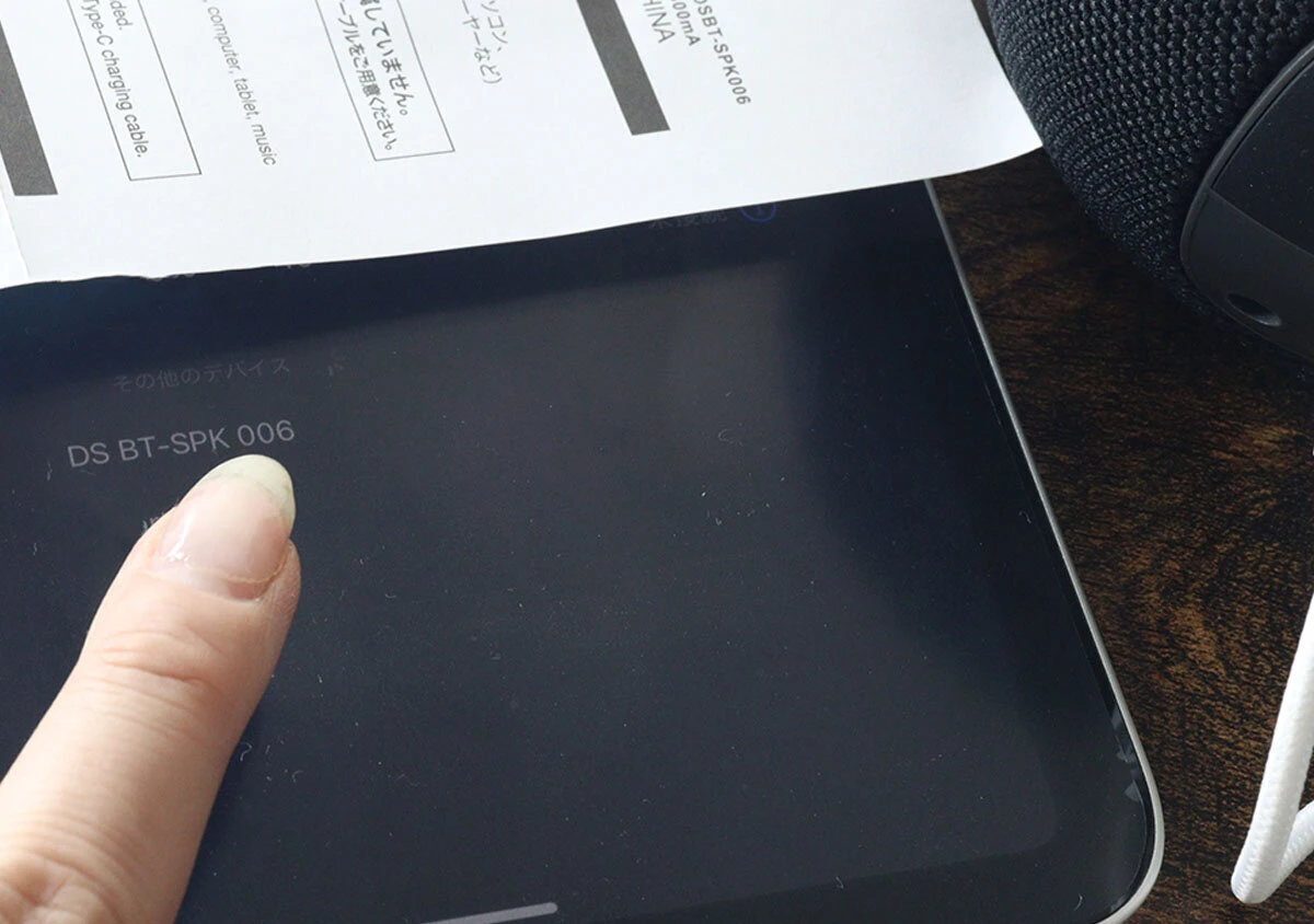 タブレット端末の画面に表示されたデバイス名を指でタップしているところ