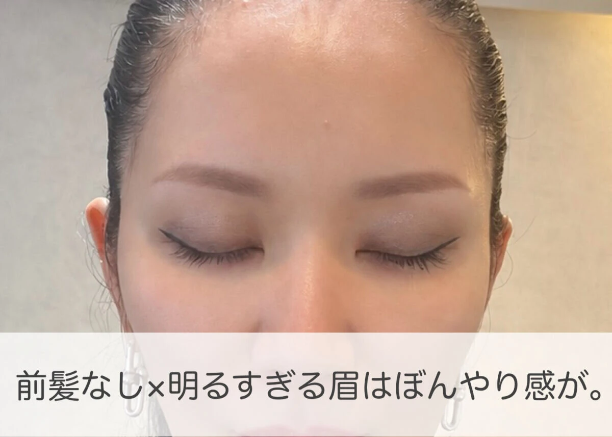 前髪なしの状態で目を閉じ、明るすぎる眉で顔がぼんやり見える女性の顔
