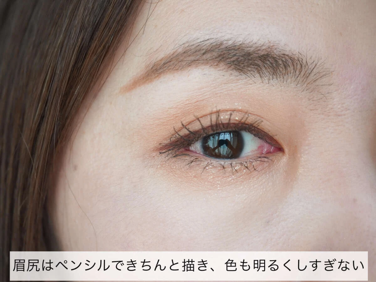 女性の顔のアップ。眉と目元にメイクが施され、眉尻がペンシルで描かれ、アイシャドウとマスカラで目元が引き締まっている。