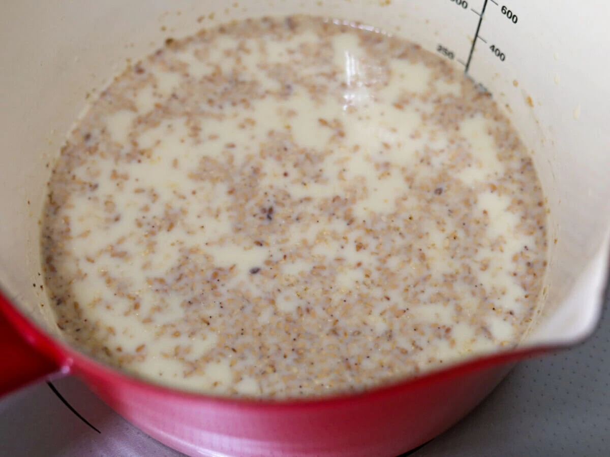 赤い小鍋の中で豆乳とすりごまが混ざり合ったスープ