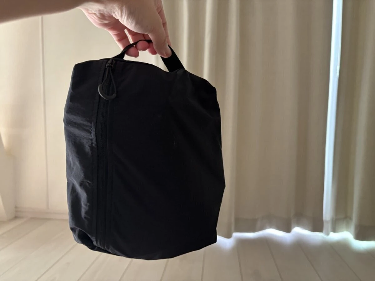 黒い手提げポーチを持って持ち上げている様子