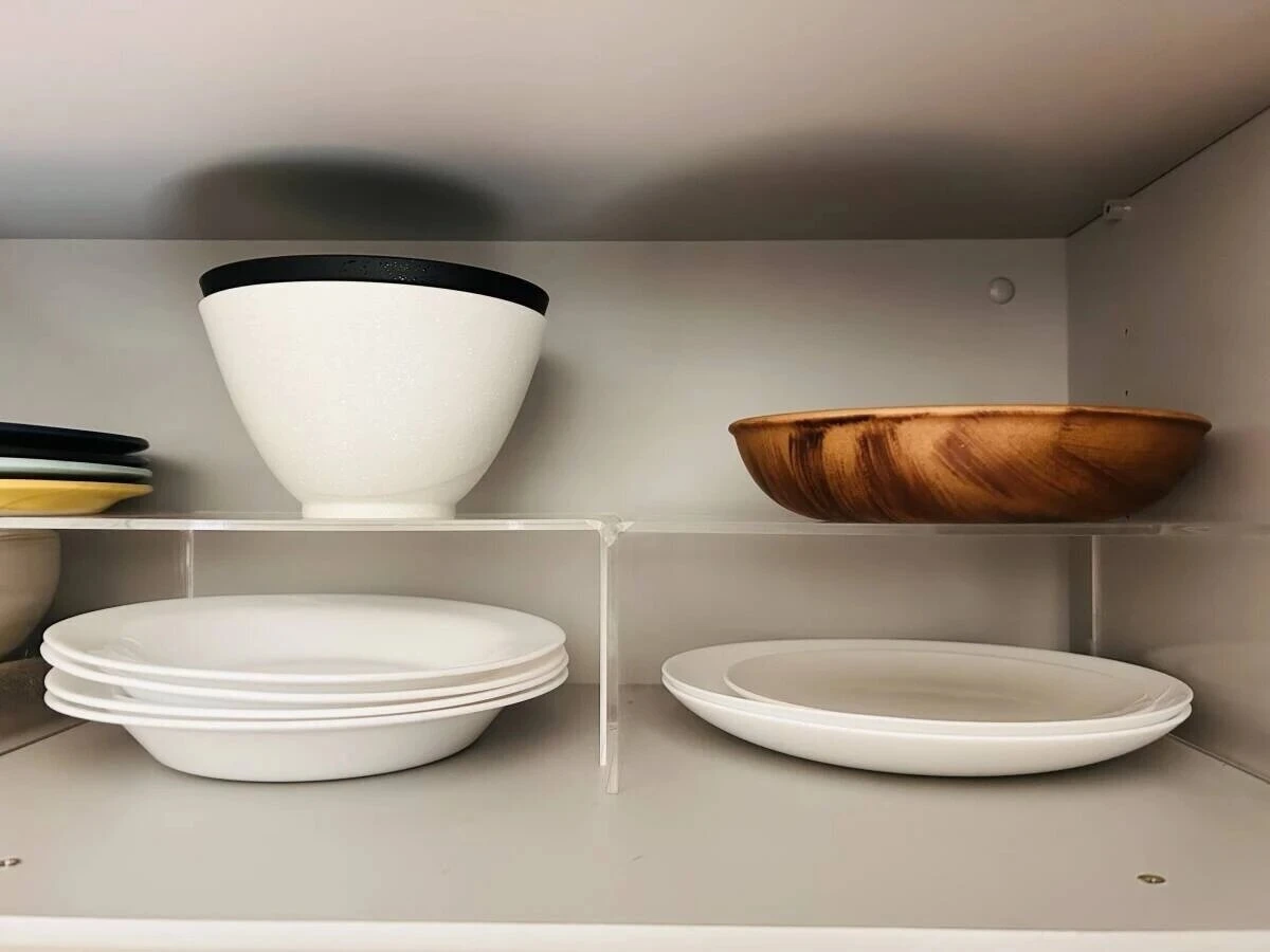 キッチンの食器棚の中でアクリル仕切棚を使いお皿を上下に分けてすっきりと収納している様子