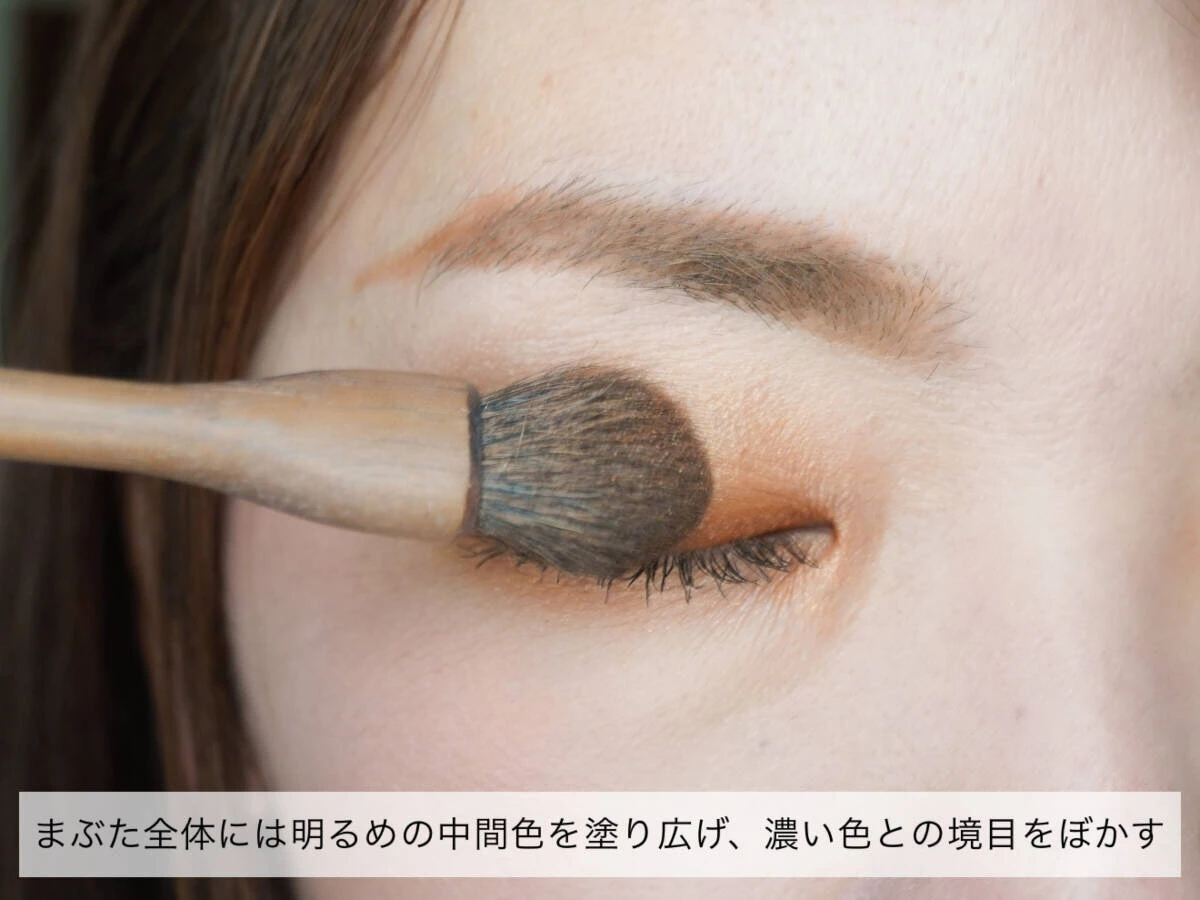 まぶたにブラシを使い中間色のアイシャドウを塗り広げているクローズアップ まぶたにブラシを使い中間色のアイシャドウを塗り広げているクローズアップ