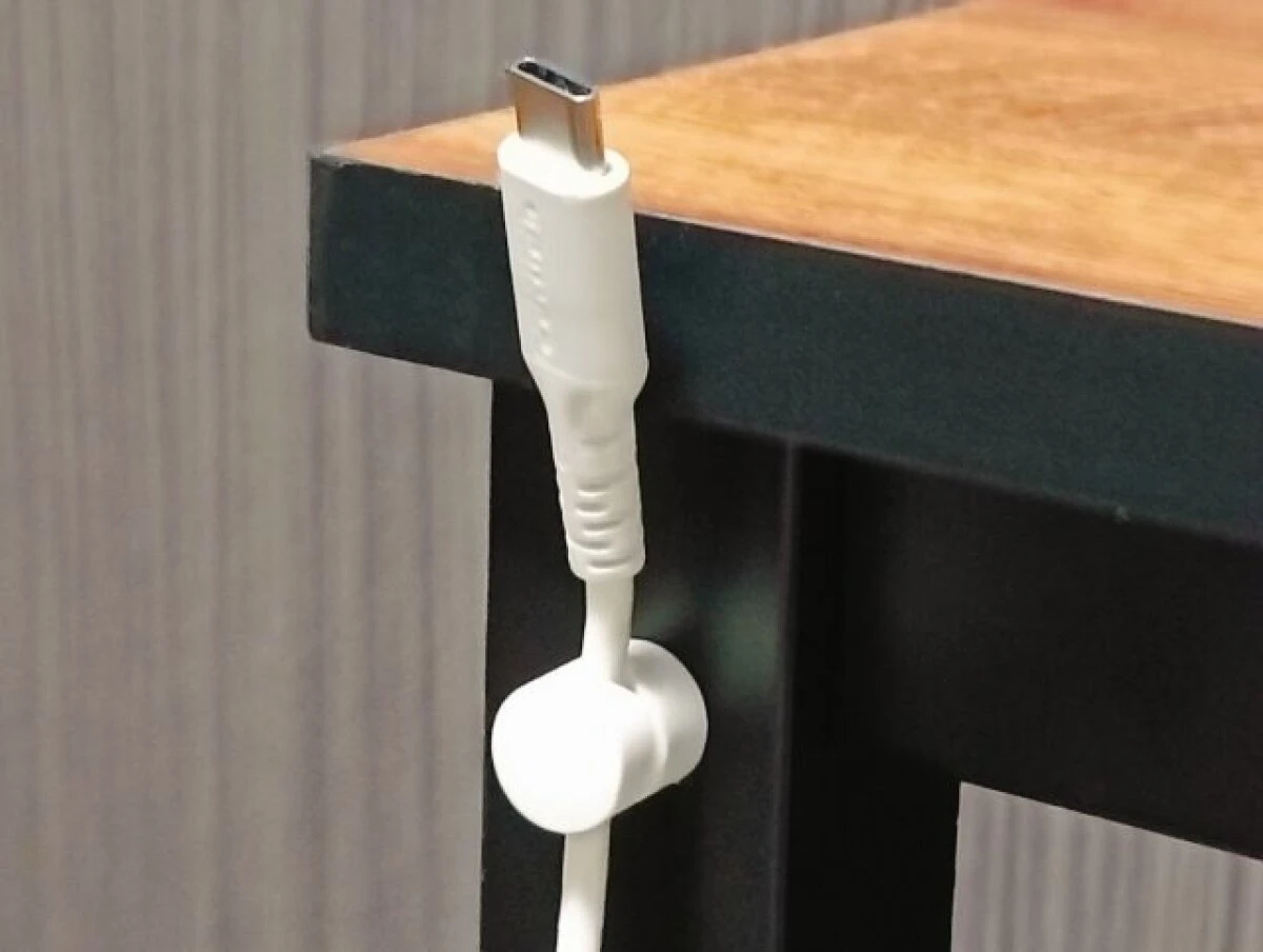 デスクの角にマグネットケーブルホルダーを取り付け充電ケーブルの先端を浮かせて固定している様子