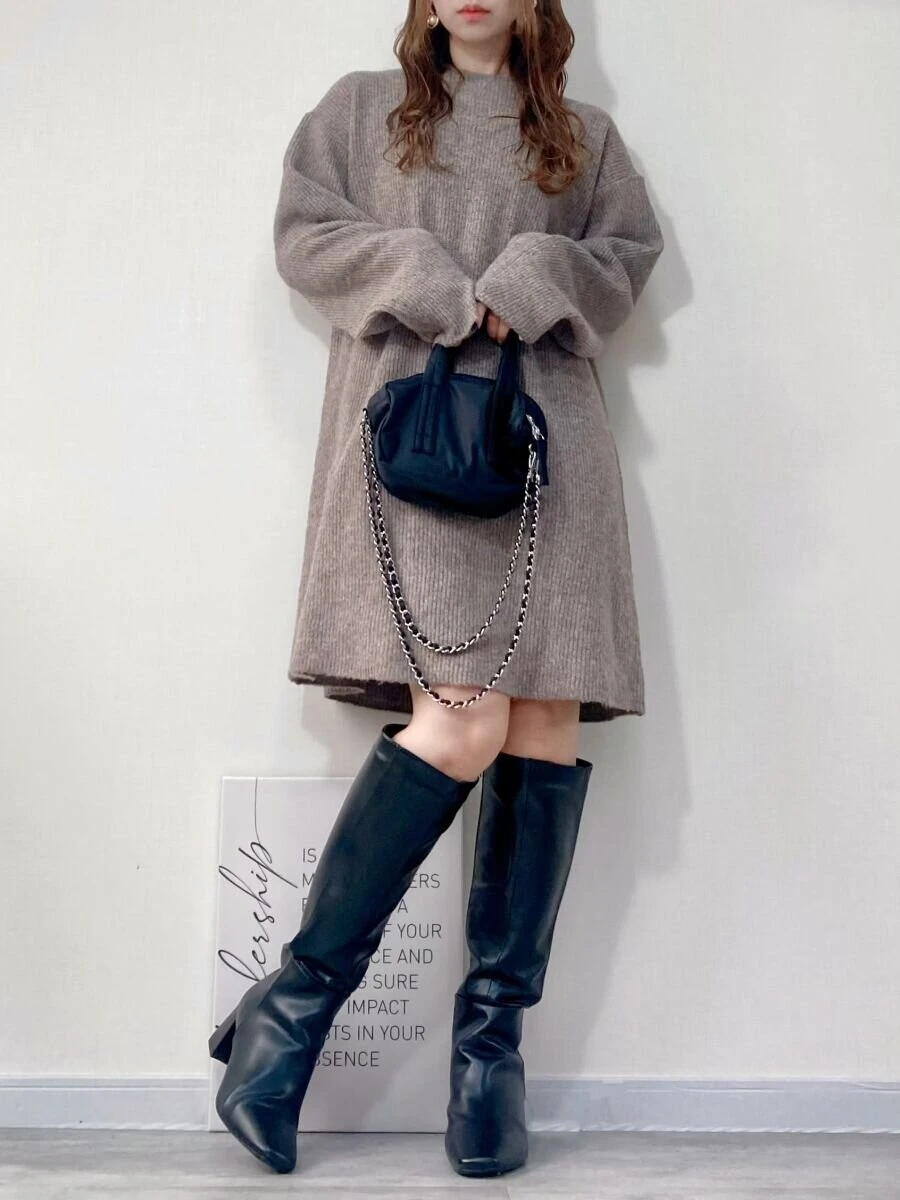 ベージュミニワンピと黒ロングブーツの女性が黒ミニボストンを持つ全身コーデ ベージュミニワンピと黒ロングブーツの女性が黒ミニボストンを持つ全身コーデ