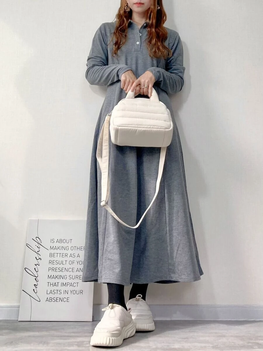 グレーのワンピースを着た女性が白いバッグを手持ちしている全身コーデ グレーのワンピースを着た女性が白いバッグを手持ちしている全身コーデ