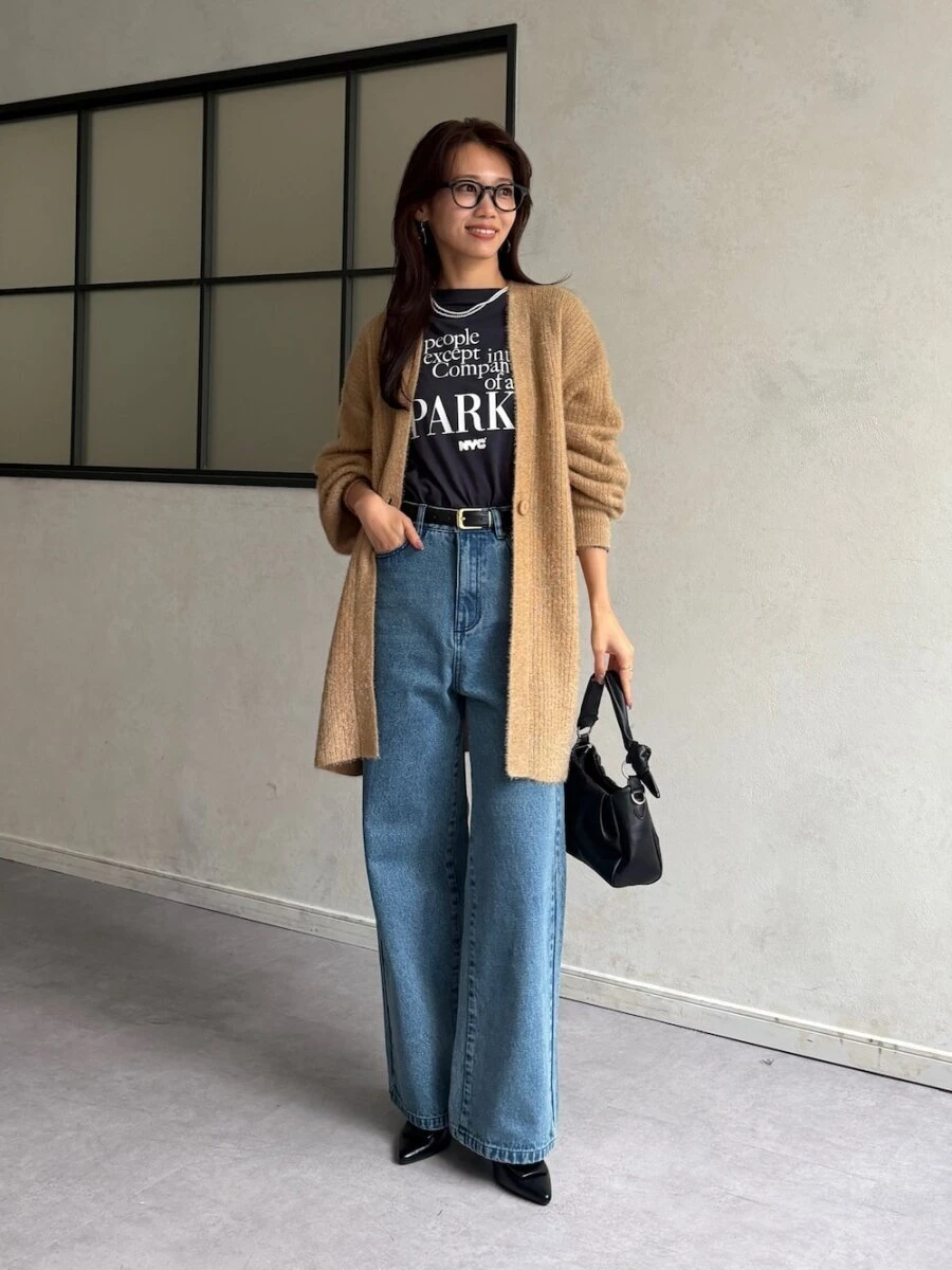 ベージュのロングカーディガンと黒Tシャツ、ブルーデニムのコーデ