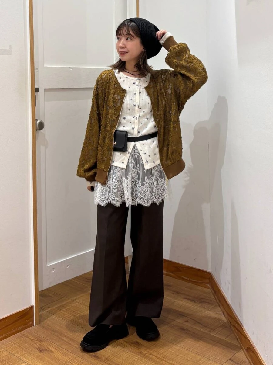 茶色のジャガードブルゾンを着て、黒いベレー帽と白いトップス、黒いパンツを合わせた女性 茶色のジャガードブルゾンを着て、黒いベレー帽と白いトップス、黒いパンツを合わせた女性