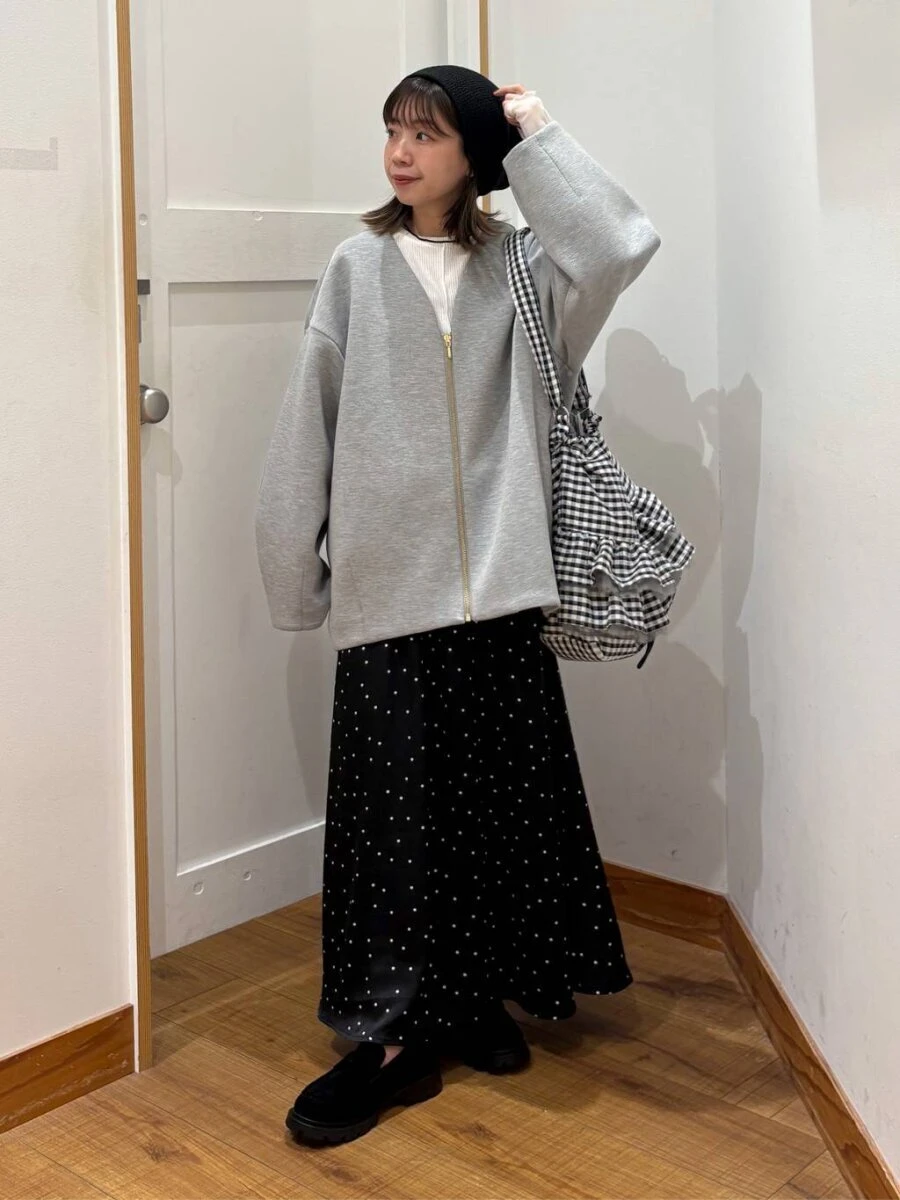 グレーのダンボールジャケットを着て、黒いベレー帽とドット柄スカートを合わせた女性 グレーのダンボールジャケットを着て、黒いベレー帽とドット柄スカートを合わせた女性