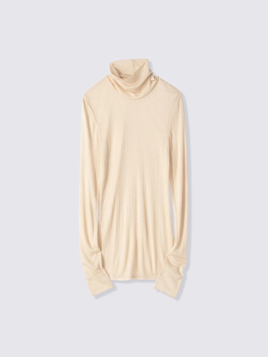 ベージュのリブ素材タートルネック長袖Tシャツ。首元にボリュームがある。 ベージュのリブ素材タートルネック長袖Tシャツ。首元にボリュームがある。
