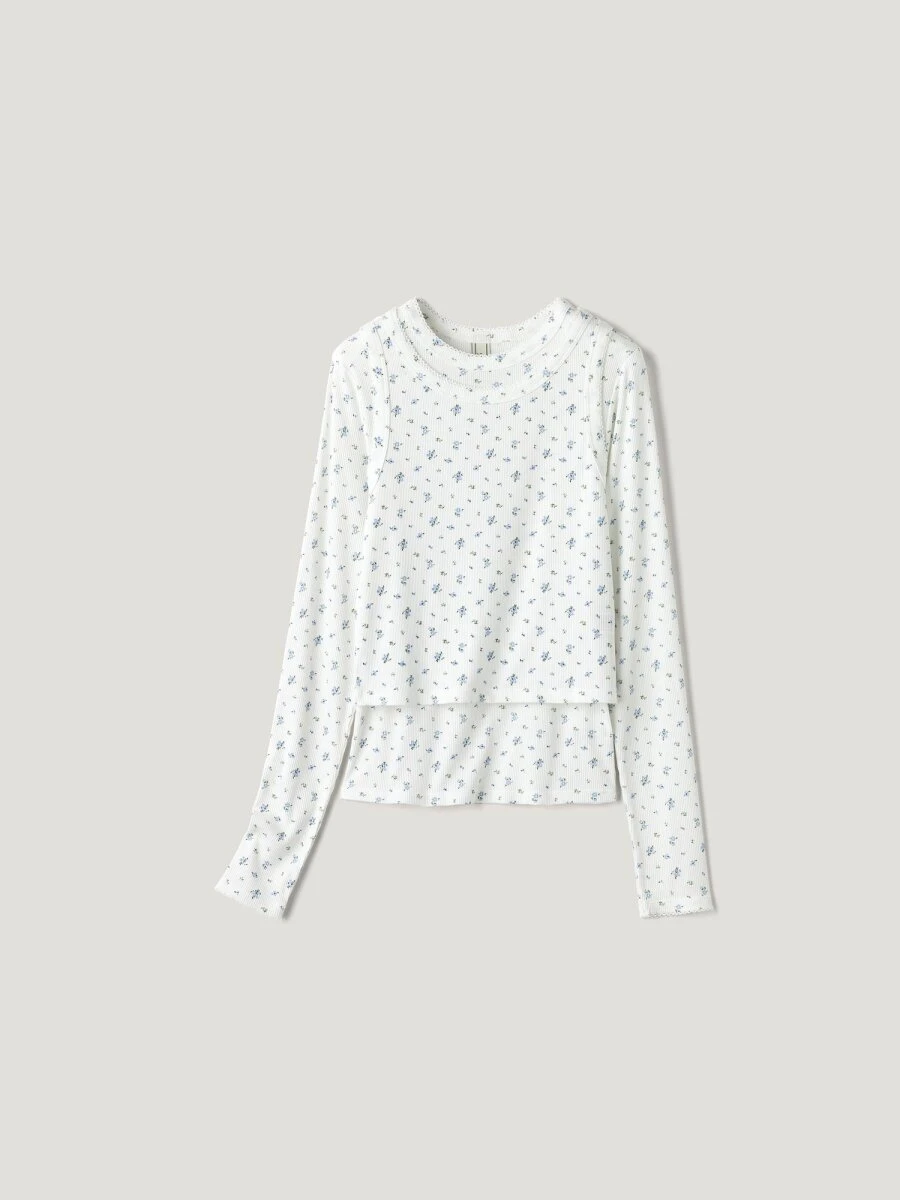 白地に青い小花柄の長袖Tシャツとタンクトップの2ピース。 白地に青い小花柄の長袖Tシャツとタンクトップの2ピース。