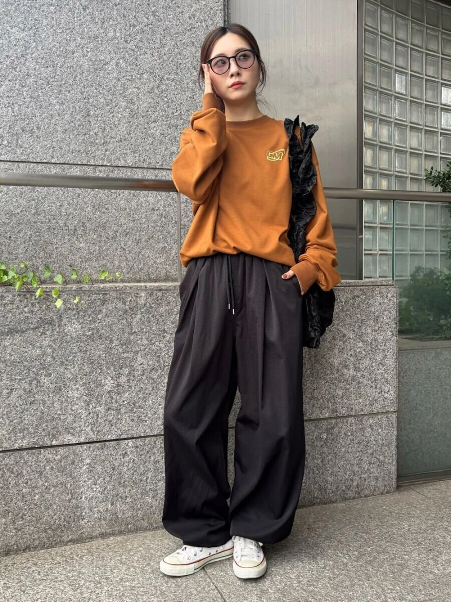 テラコッタスウェットと黒ワイドパンツのコーデ
