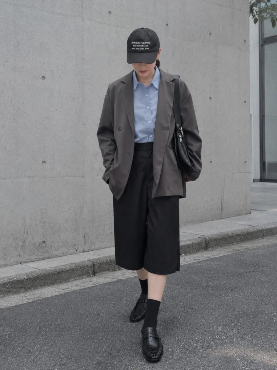 キャップとハーフパンツにジャケットを合わせた女性の全身写真 キャップとハーフパンツにジャケットを合わせた女性の全身写真