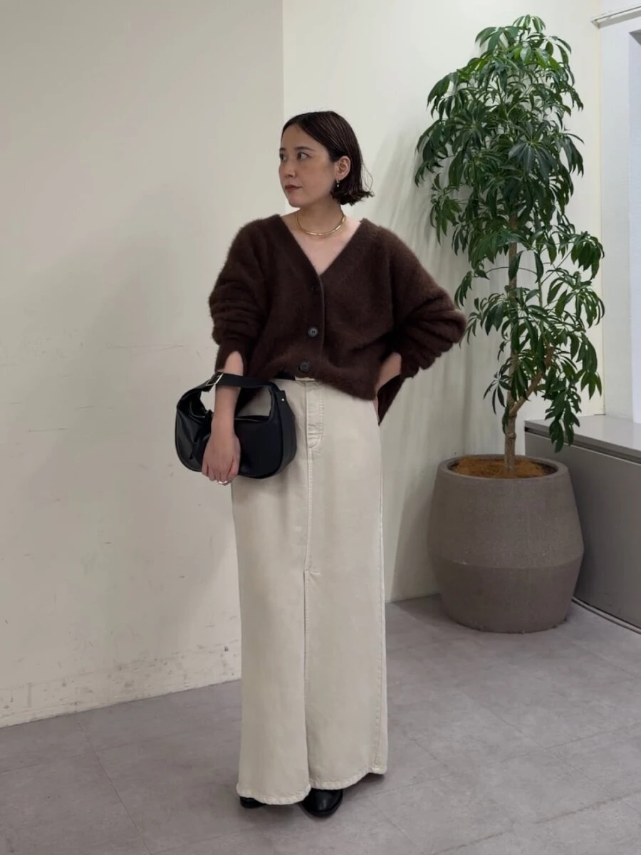 ブラウンのふわふわカーディガンに白のロングスカートを合わせた明るいトーンの女性 ブラウンのふわふわカーディガンに白のロングスカートを合わせた明るいトーンの女性