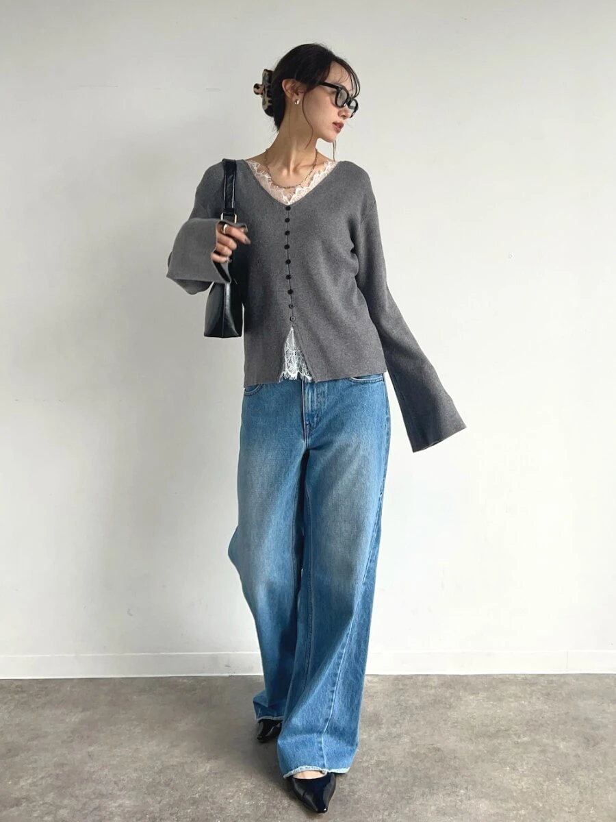 レースディテールのグレーカーディガンを着てバッグを持つ女性