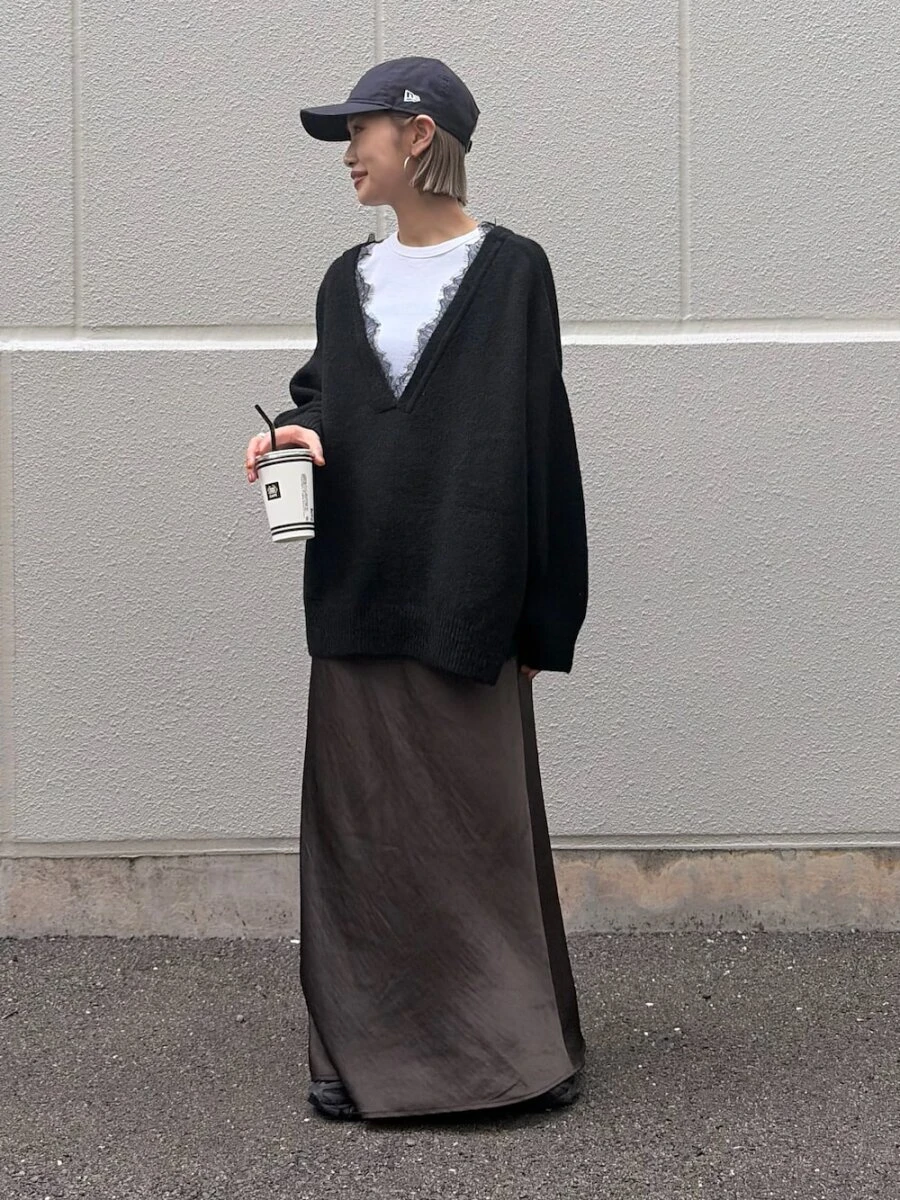 黒の深Vネックニットとチャコールグレーのサテンスカートのコーデ