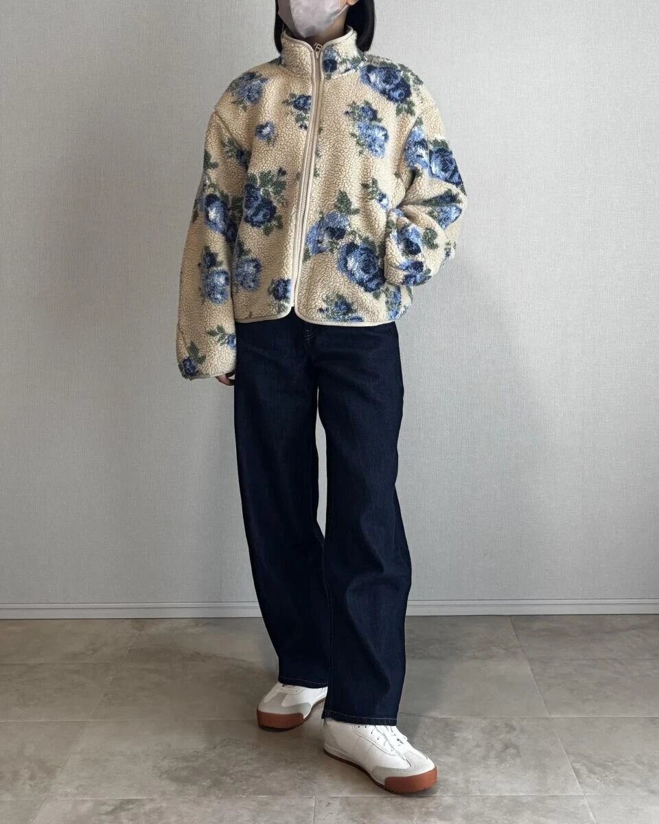 ベージュの花柄フリースジャケットにネイビーのバレルレッグデニムを合わせた全身写真 ベージュの花柄フリースジャケットにネイビーのバレルレッグデニムを合わせた全身写真