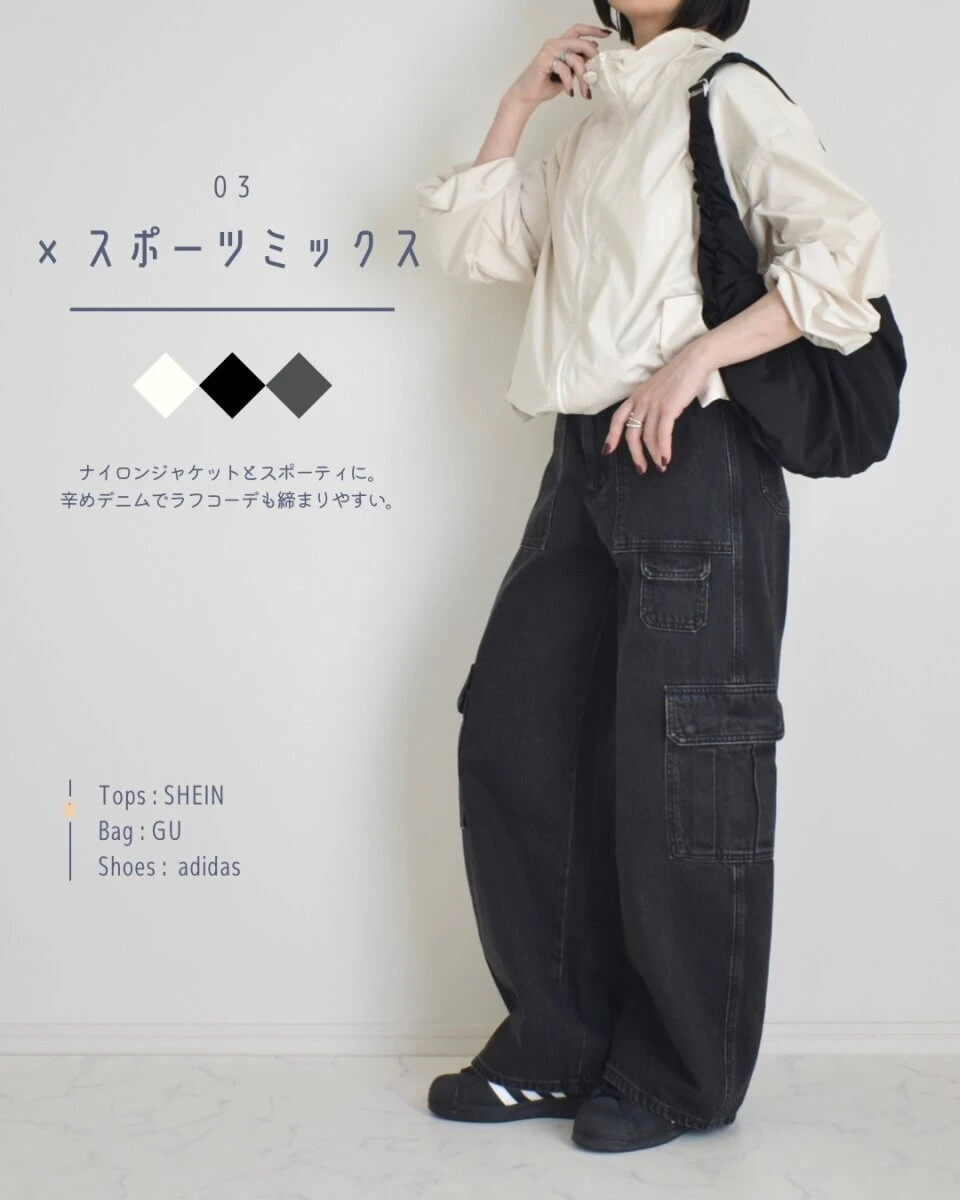 黒いバレルユーティリティジーンズと白いナイロンジャケットを着用し、黒いバッグを持つ女性の全身